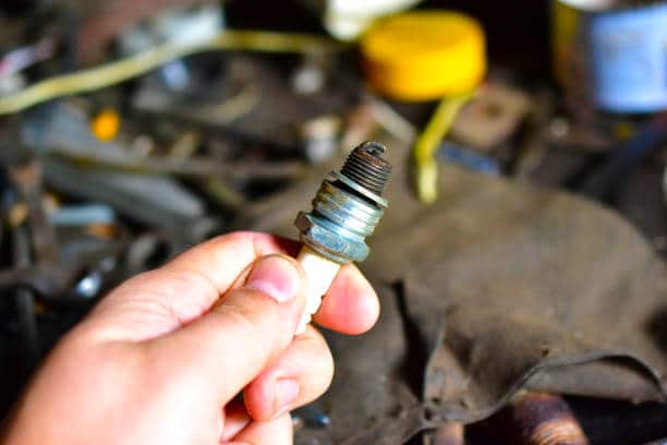 Car spark plug in hand in the garage